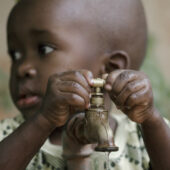 A Child in Africa playing with a water tap