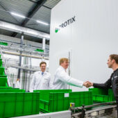 King Willem Alexander of The Netherlands shaking hands with an employee at Protix factory with green boxes