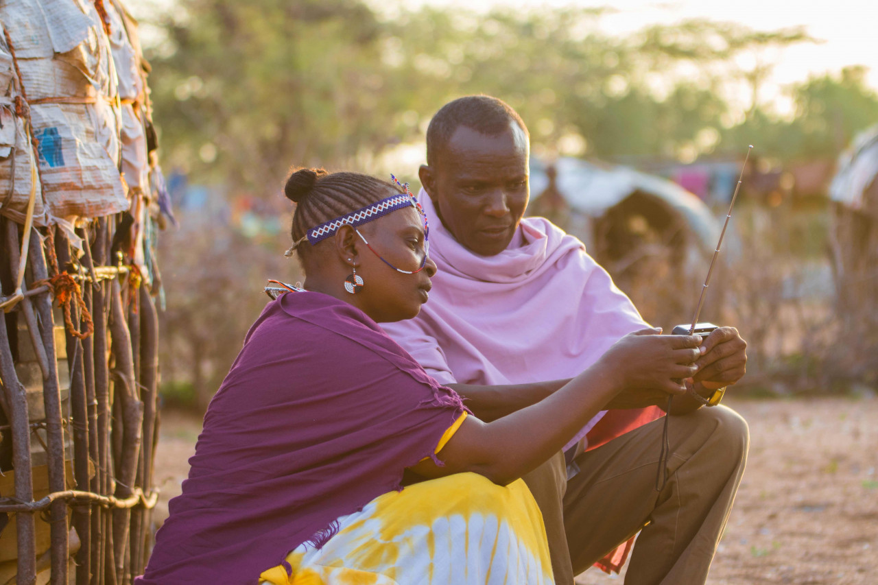 Couple looking at a radio in sub-Saharan Africa, powered by off-grid solar energy