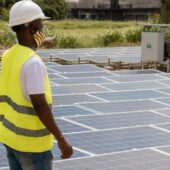 Constructor pointing at solar panels in Ghana