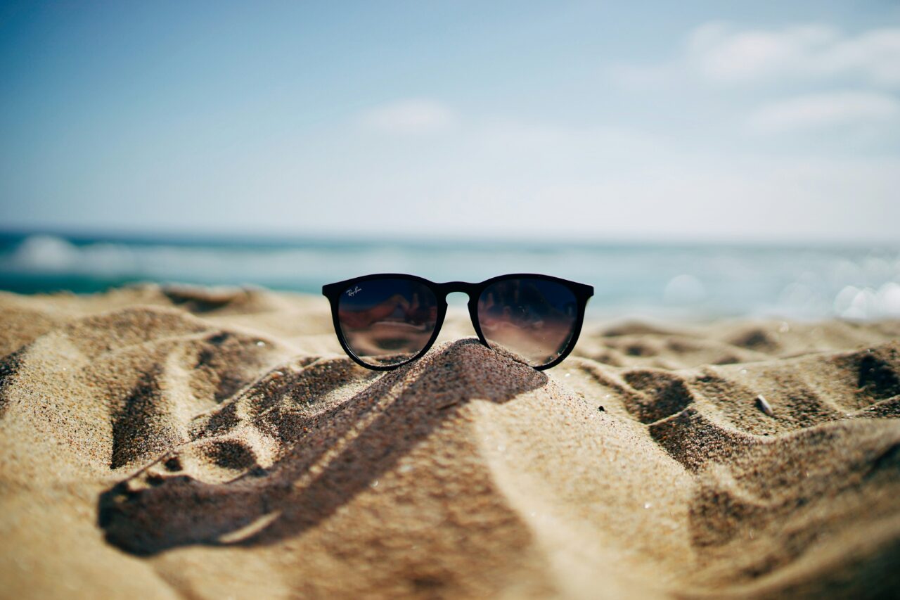 Sunglasses on a beach with the sea, ocean, sand, summer, holiday, vacation