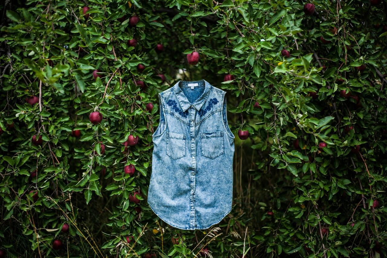 sustainable fashion blue denim against a fruit foliage green